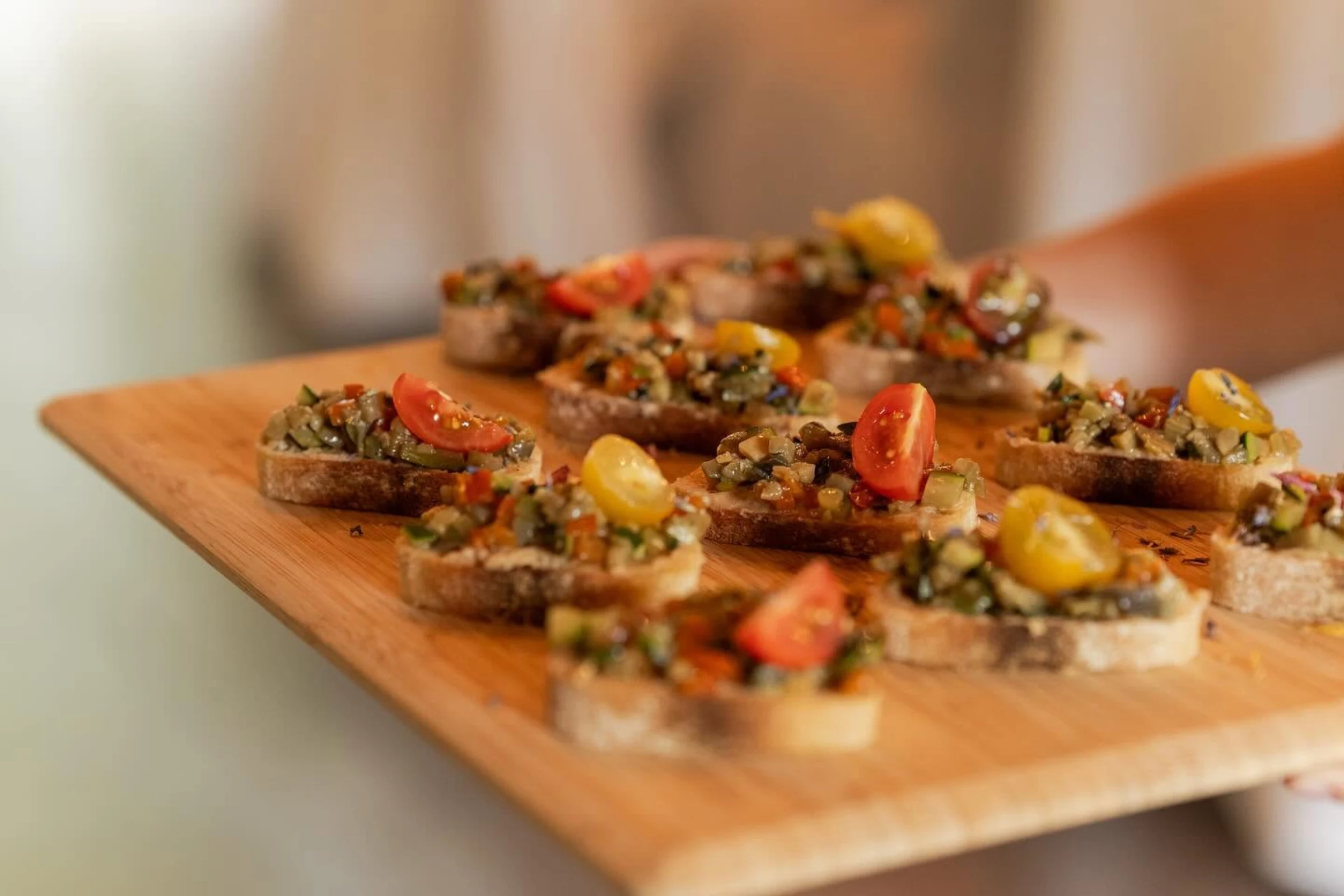 Bruschettas aux légumes grillés dressées sur une planche, préparées par LéLu Traiteur